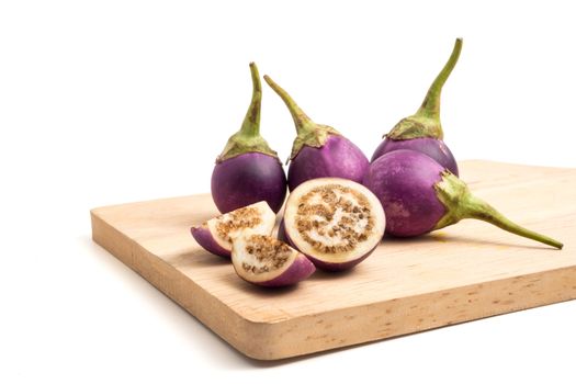 Fresh Purple eggplants on wooden tray over white background.