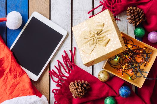 Top view of Tablet and christmas decoration on wooden table.
