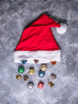 Top view of santa hat with christmas decoration on gray grunge background.