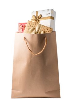 Gift boxes in brown paper bag on white background.