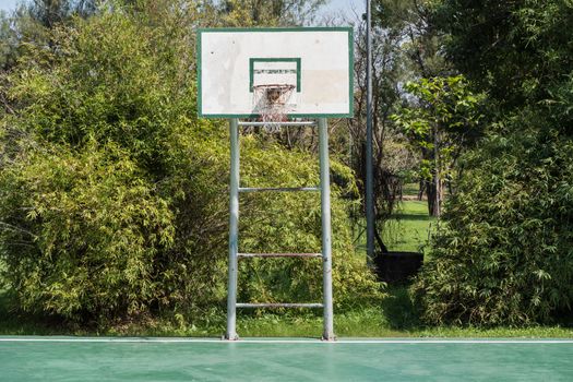 A backboard on basketball court in a park.