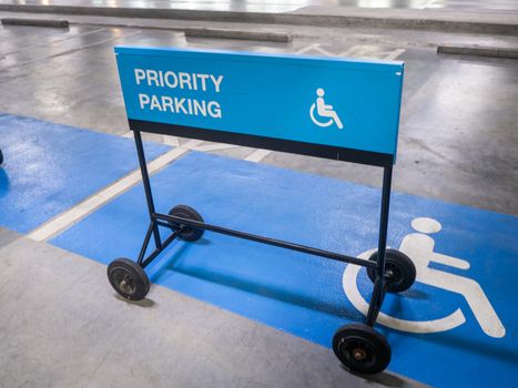 The international sign for a handicapped parking stall in a parking lot. Priority parking sign.