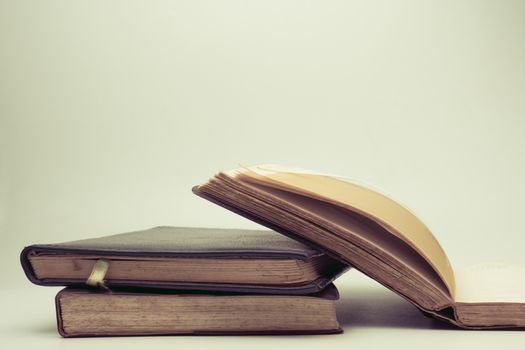 A stack of old books with vintage background.