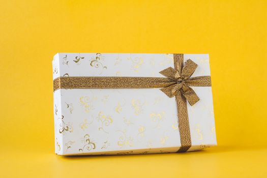 White gift box on a yellow background.