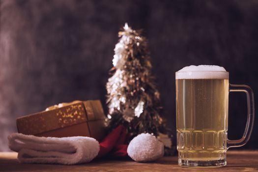 Mug of beer with Christmas decorations on the wooden table.
