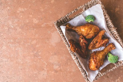 Top view of Fried chicken legs and wings in basket. Free space for text