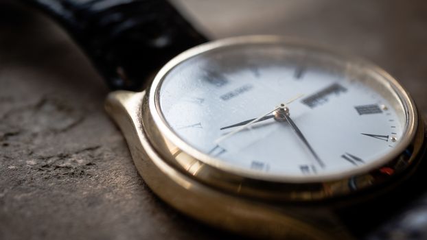 Close up front view of a modern wrist watch on the table. Soft focus