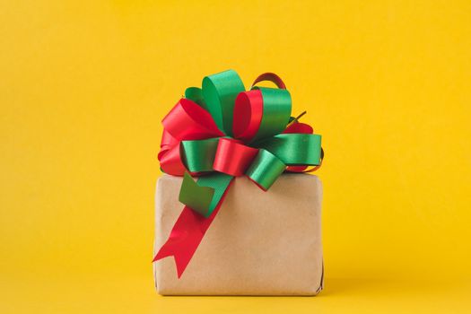 Gift packages wrapped in brown paper with bow on yellow background.