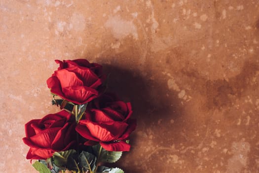 Bunch of Red roses on brown grunge board background. Free space for text