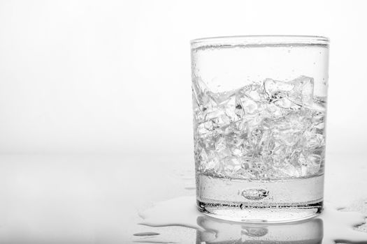 Glass of pure water with ice cubes.