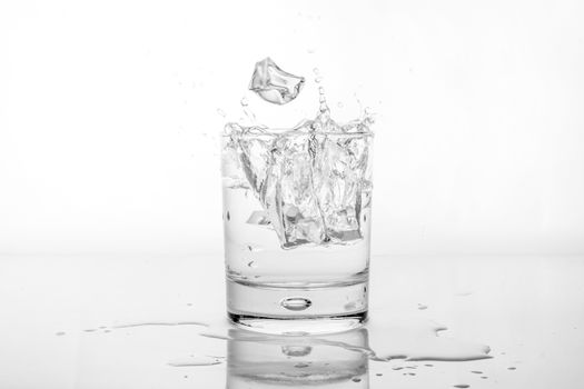 Splashing of water with ice in glass