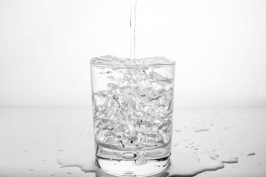 glass with ice and splashing water