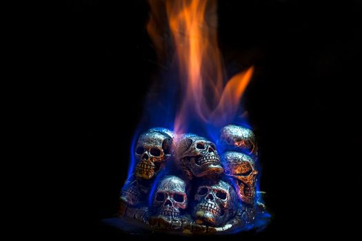 Burning skulls on black background