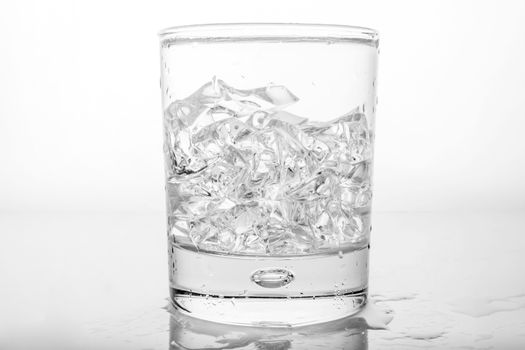 Glass of pure water with ice cubes.