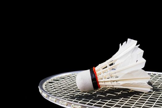 Shuttlecock and badminton on dark background