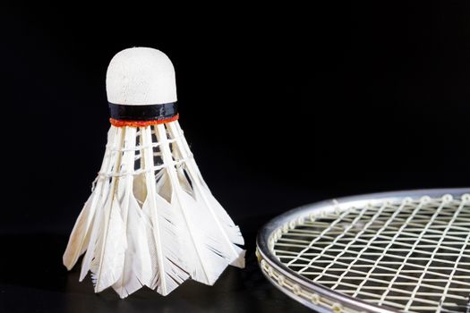 Shuttlecock and badminton on dark background