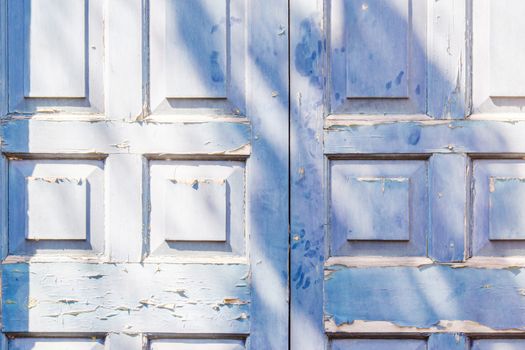 Blue door with squre pattern and peeling paint