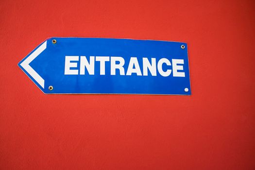 Entrance Sign mounted on a bright red wall UK