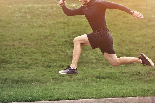 Portrait of concentrated confident muscular full of strength sportsman wearing shorts and sneakers.