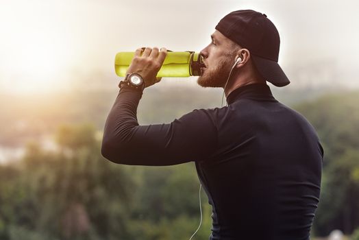 Close-up Shot Bearded Sportive Man take a rest and drink a water After Workout Session.