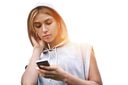 Beautiful young woman with headphones glad after nice jogging in city park