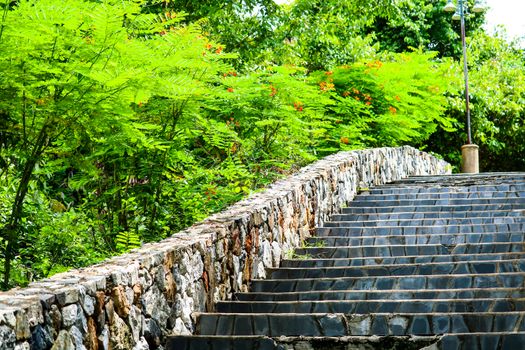 Granite stairs and stone walls in the garden and green trees