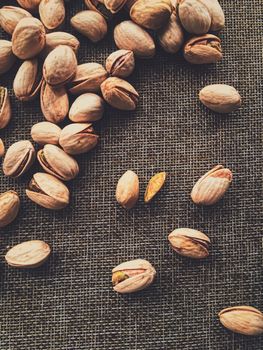 Pistachio nuts on rustic linen background, food and nutrition