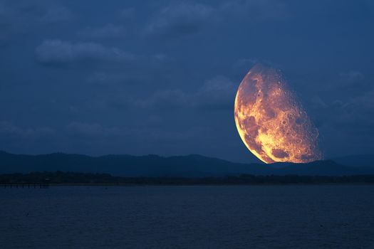 half moon floating in sky back on silhouette mountain ,Elements of this image furnished by NASA
