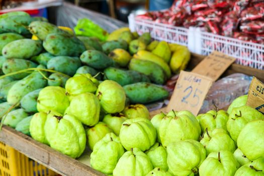 green mango and fresh fruits on table in fresh market