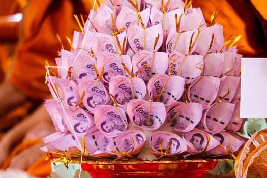 Banknotes are finely folded to decorate on the golden plate to give to the Buddhist temple