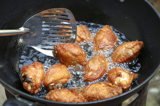 Fried chicken in a pan with hot oil. Golden yellow fried chicken in a pan.