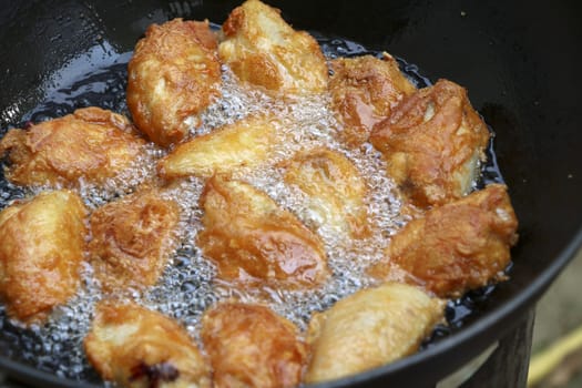 Fried chicken in a pan with hot oil. Golden yellow fried chicken in a pan.