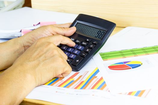 Employees use office calculators with documents of income, expenses, concept of life at work.