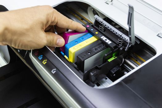 Technicians are install setup the ink cartridge of a inkjet printer the device of office automate for printing