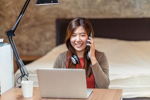 Asian business woman using technology laptop and working from home in bedroom, video conference and calling,startups and business owner,lifestyle occupation,social distancing and self responsibility
