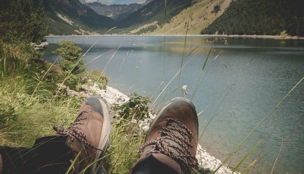 hiker taking a break sitting near the lake of Oule in valley of Aure in Haute-Bigorre in the department of Hautes-Pyrénées in France