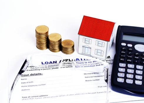 Mortgage Loans concept with close up Loan application form and eyeglasses and coins stack and paper house and calculator