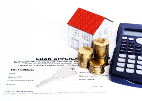 Home key and coins stack and paper house and calculator on Loan application form for loan concept