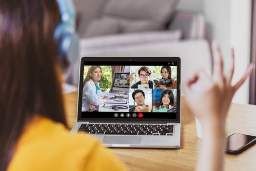 Rear View of Asian Business woman discussing with doctor and teamwork colleague to follow up sickness in video conference when Coronavirus outbreak, Covid-19 pandemic,online meeting and new normal