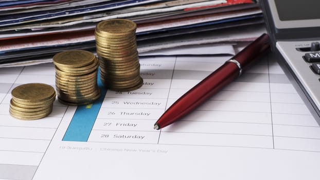 money coins stack and red pen for due date payment concept background