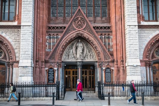 Dublin, Ireland - February 13, 2019: Street atmosphere and architecture of St. Augustine and St. John The Baptist Catholic Church that people visit on a winter day