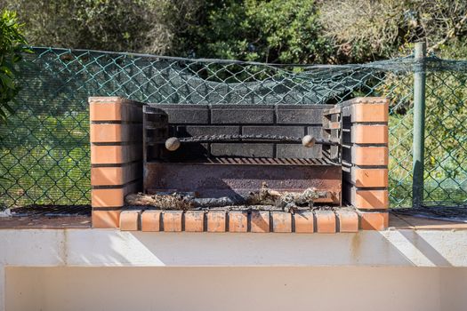 Charcoal barbecue in red brick in a garden in Portugal