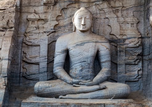 Buddha in rock carving statue sitting on lotus stand Buddhist temple.