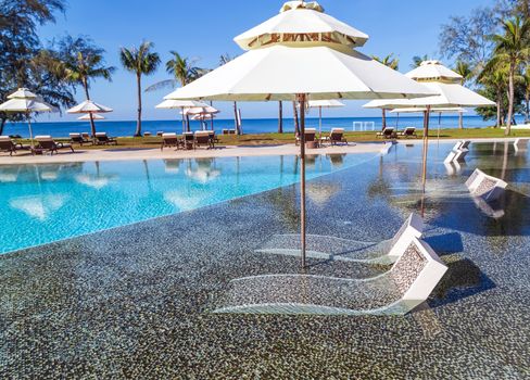beach loungers and umbrellas at white sandy beach Tropical vacations resort landscape