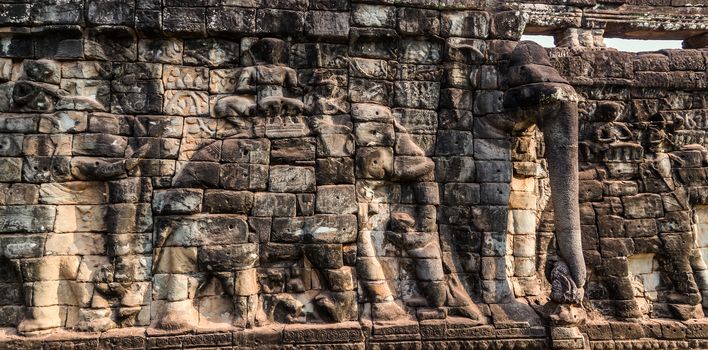 Low relief carving decorative sanctuary sculpted elements Ancient bas-relief decorated temple old ruin stone wall of Angkor wat complex Siem Reap UNESCO World Heritage Site Cambodia.
