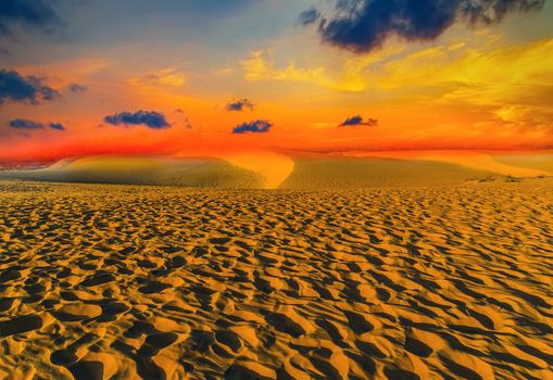 Footprints in the sand at sunset Travel concept