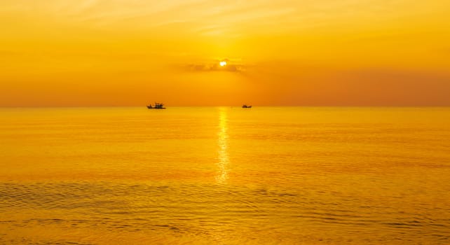 panoramic view of tropical surfers at sunset