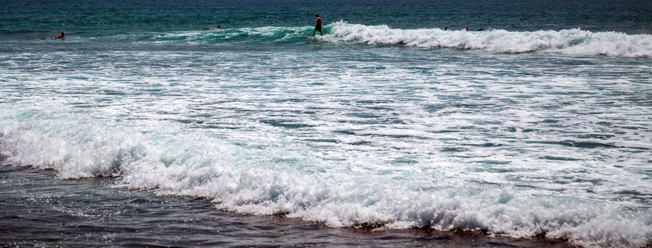 Surfer on a surfboard in the sea water splash blue transparent surf fresh ocean water background island of Bali Indonesia.