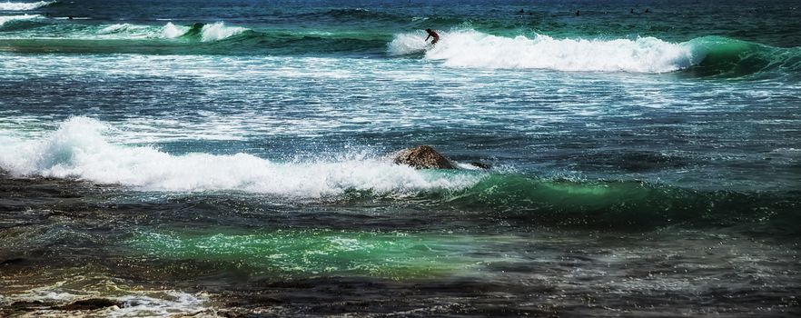 Surfer man on Blue Ocean Wave Bali Indonesia water sport lessons swimming activity riding waves