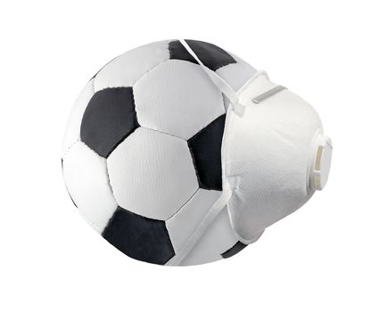 White medical surgical mask on Leather black and white Ball Football Soccerball side view isolated on white background. Face mask KN95 or N95 respirator protection flu virus coronavirus COVID-19.